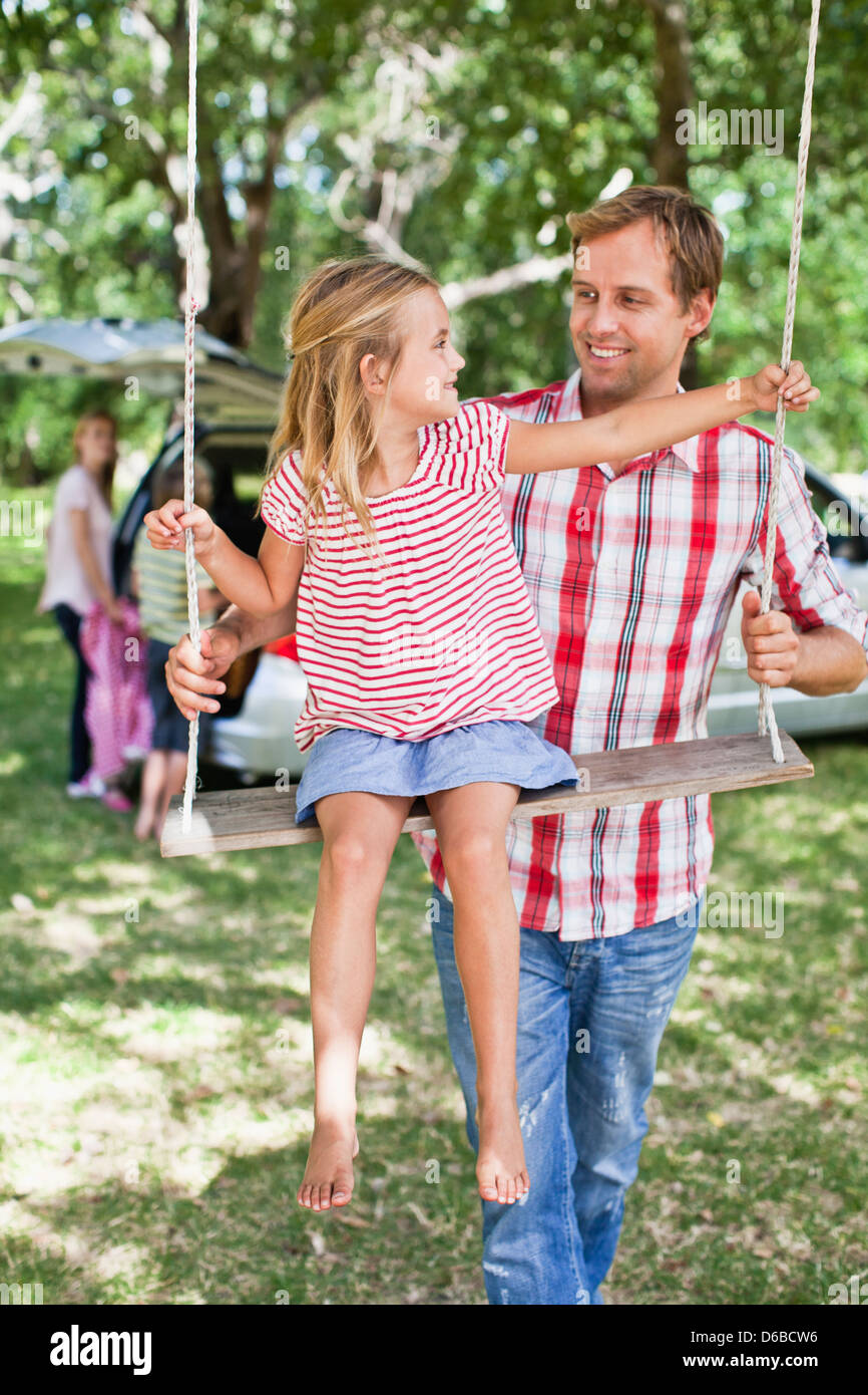 Père fille poussant on swing Banque D'Images