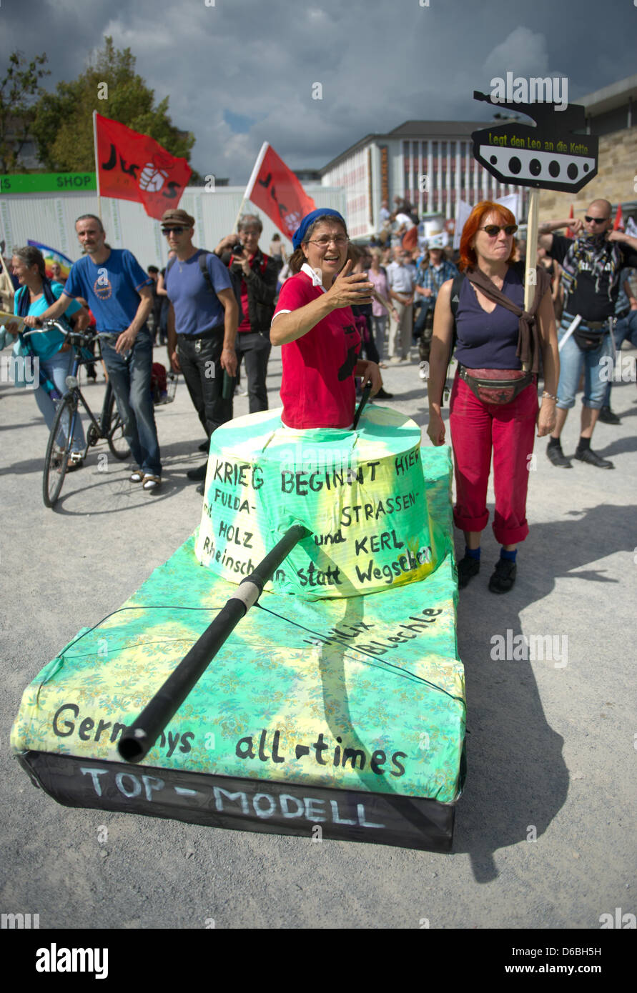 Une femme donne à partir d'un réservoir en carton dans la ville de Kassel, Allemagne, 31 août 2012. Près de 350 personnes, protesté pacifiquement contre les exportations d'armes nucléaires dans la région de Kassel à la compagnie d'armement Krauss-Maffei Wegmann, selon la police. Le rallye a été demandée par diverses initiatives de paix, des groupes étudiants et des partis politiques. Photo : UWE ZUCCHI Banque D'Images