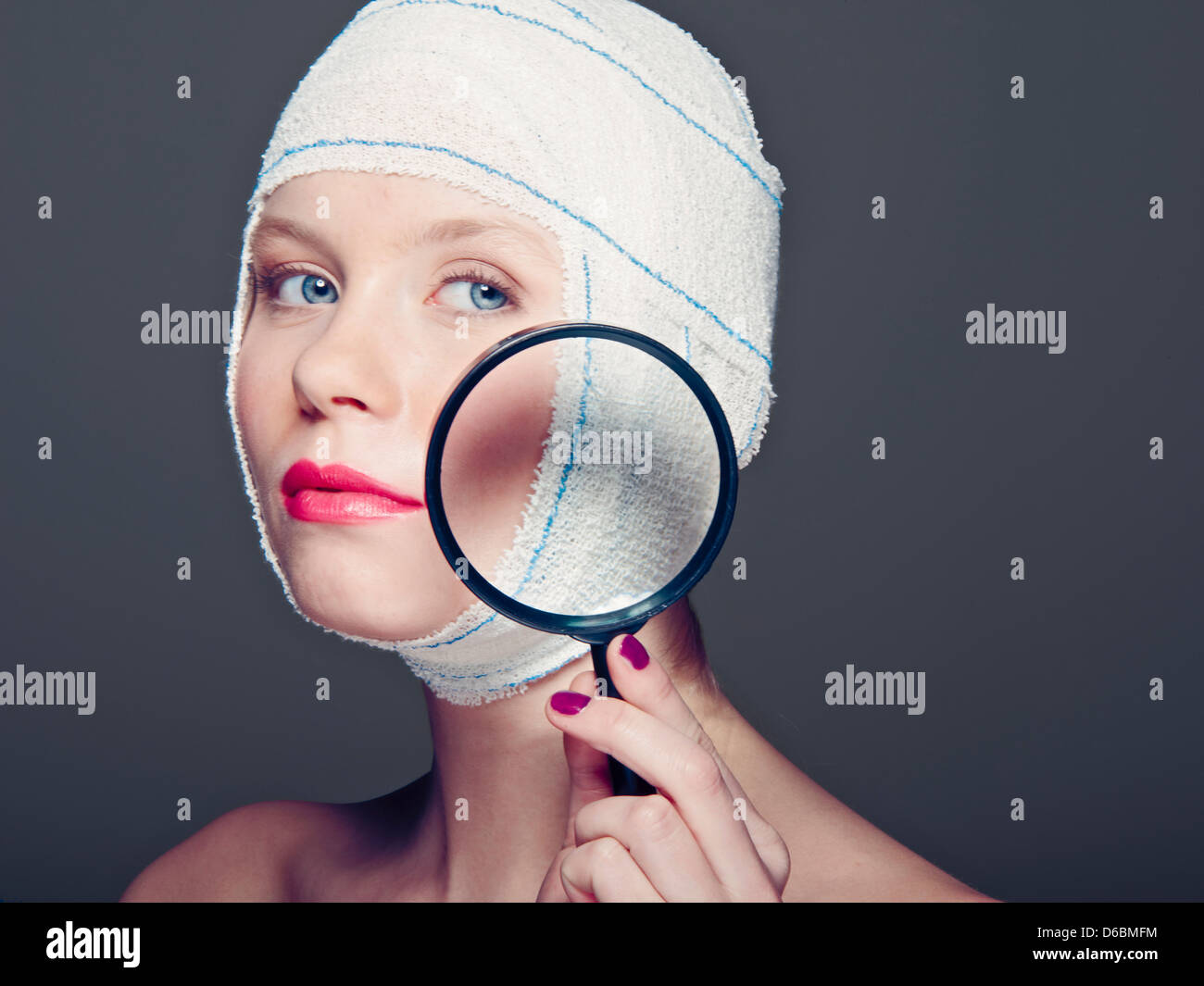 Femme dans les bandages avec loupe Banque D'Images