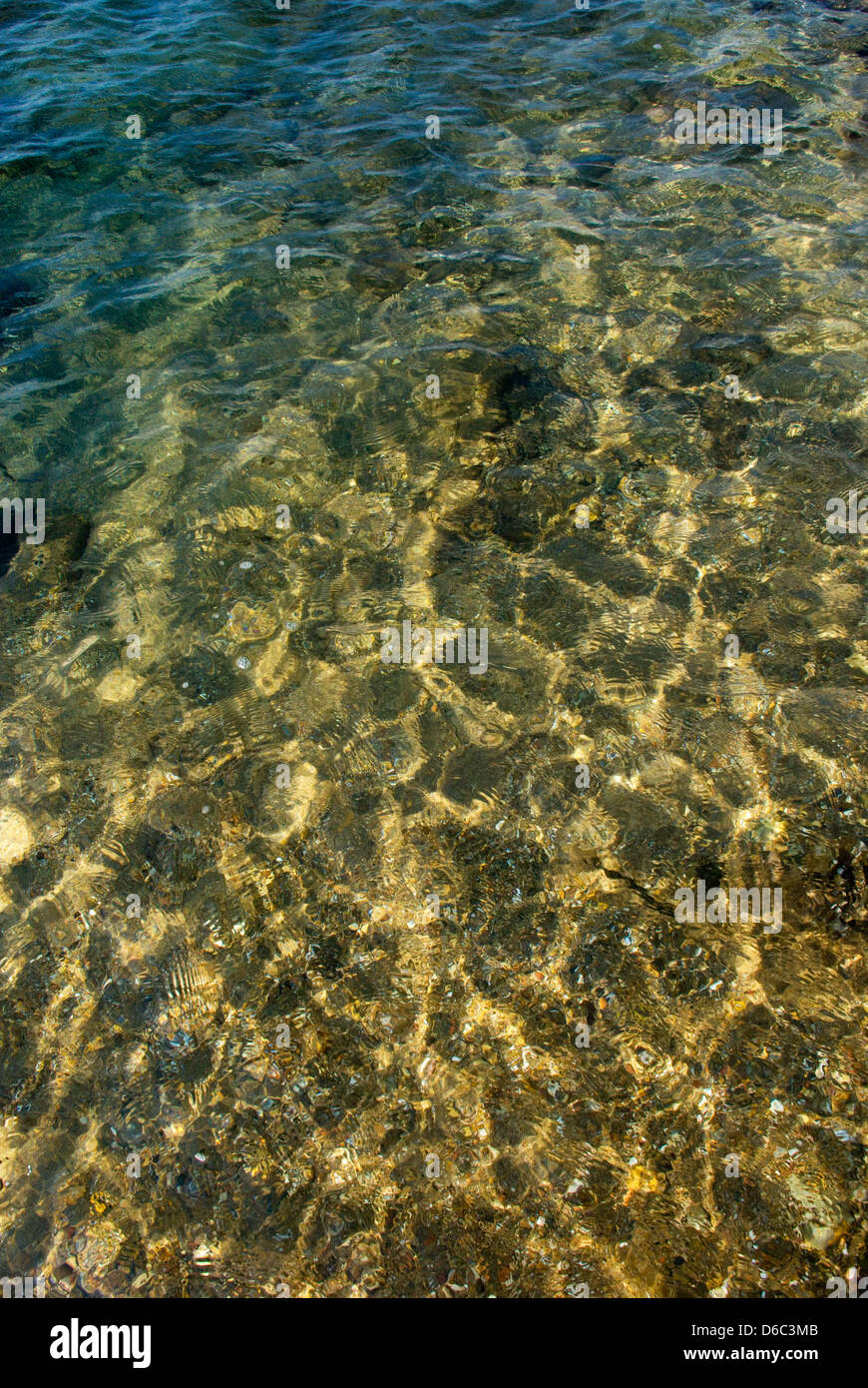 Plage de galets sous l'eau claire avec des vagues Banque D'Images