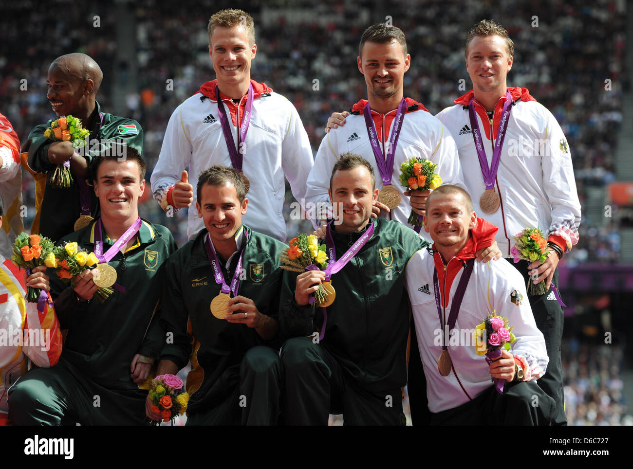 L'équipe du relais Allemand Markus Rehm (l-r au-dessus), Heinrich Popow, David Behre et Wojtek Czyz sont vus avec leurs médailles de bronze et d'Afrique du Sud et de l'équipe du relais médaillé d'Samkelo Radebe (l-r), Zivan Smit, Arnu Fourie et Oscar Pistorius durant la cérémonie de la victoire pour les hommes du 4x100m relais -T42-46 au Stade olympique durant les Jeux Paralympiques de 2012 à Londres, Londres, Grande-Bretagne, Banque D'Images