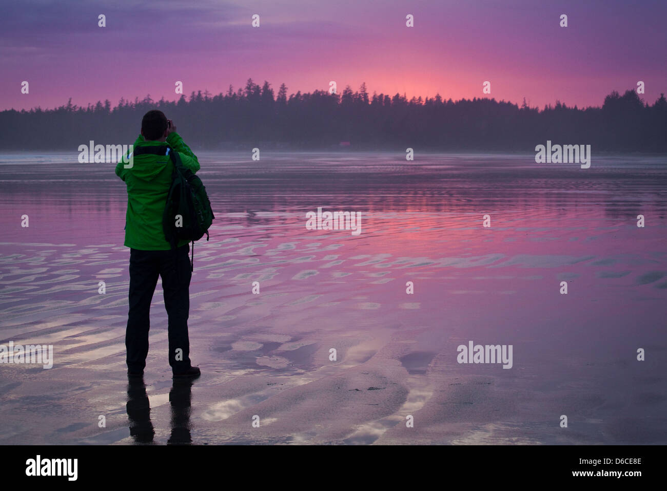 Un homme photographies le coucher de soleil sur Long Beach, près de Tofino, Vancouver Island Banque D'Images