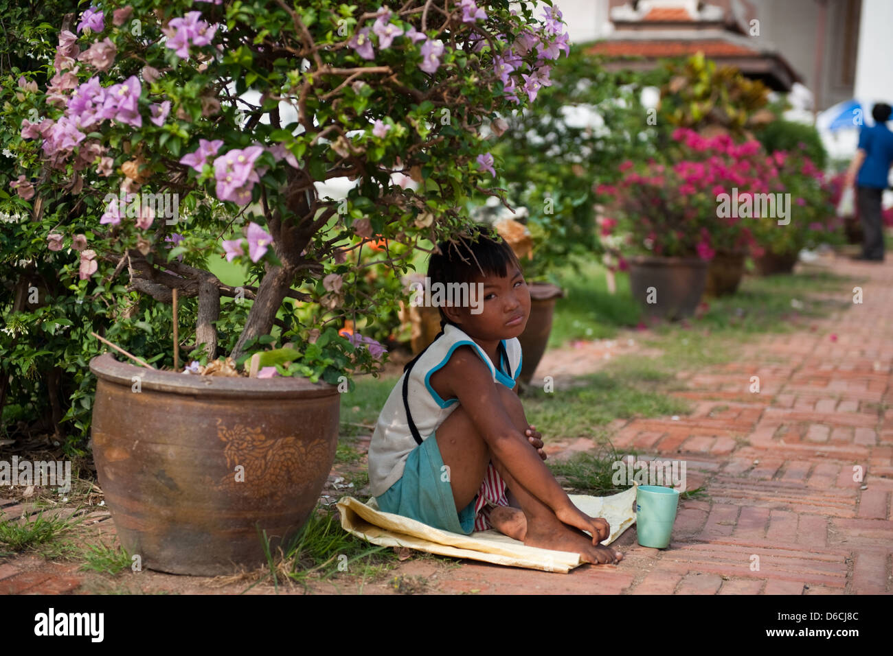 Ayutthaya, Thaïlande, un mendiant garçon en face de Wihan Phra Mongkhon Bophit Banque D'Images