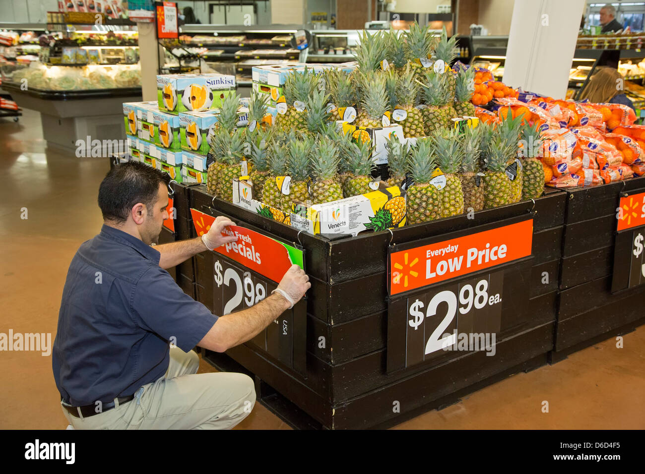 Sterling Heights, Michigan - un travailleur remplace le signe dans la section des fruits et l'article d'un magasin Walmart. Banque D'Images