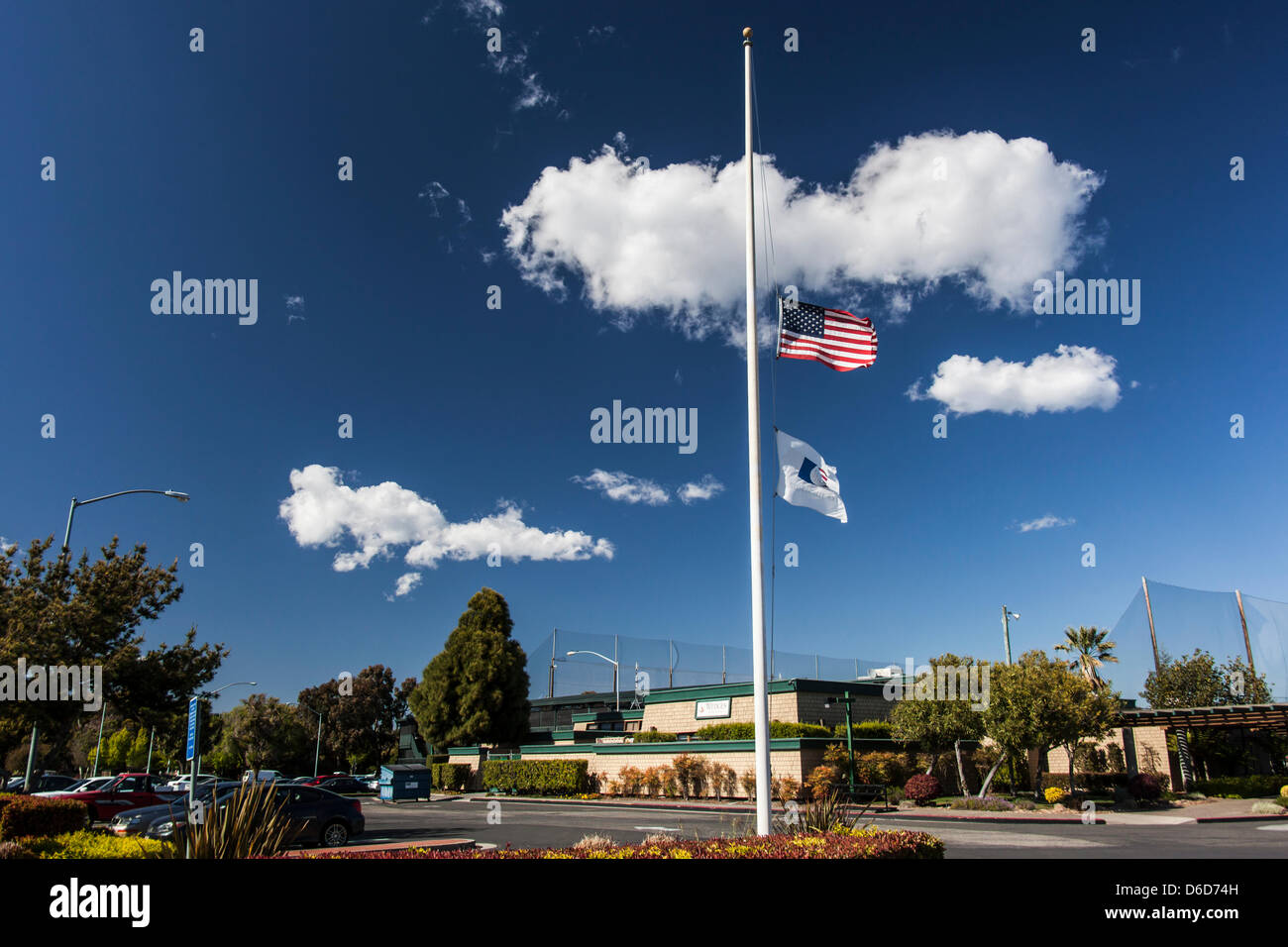 Le drapeau américain et l'American Golf Flag flotter en berne à l'extérieur de la Tony Lema Golf, un terrain de golf municipal à San Leandro, en Californie, plus de 3 000 kilomètres de Boston, Massachusetts, et l'attentat du Marathon de Boston. Banque D'Images