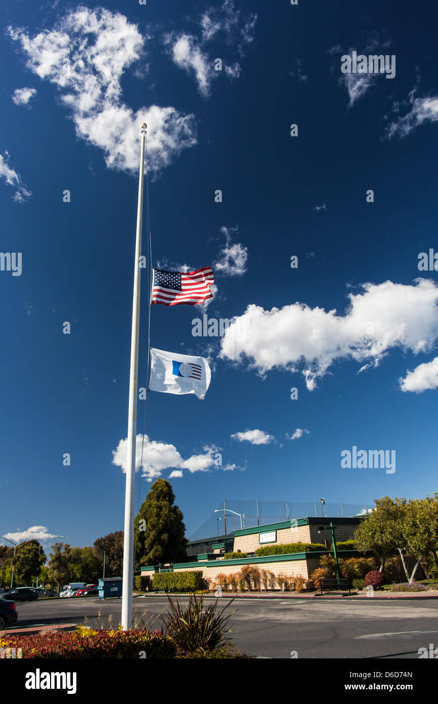 Le drapeau américain et l'American Golf Flag flotter en berne à l'extérieur de la Tony Lema Golf, un terrain de golf municipal à San Leandro, en Californie, plus de 3 000 kilomètres de Boston, Massachusetts, et l'attentat du Marathon de Boston. Banque D'Images