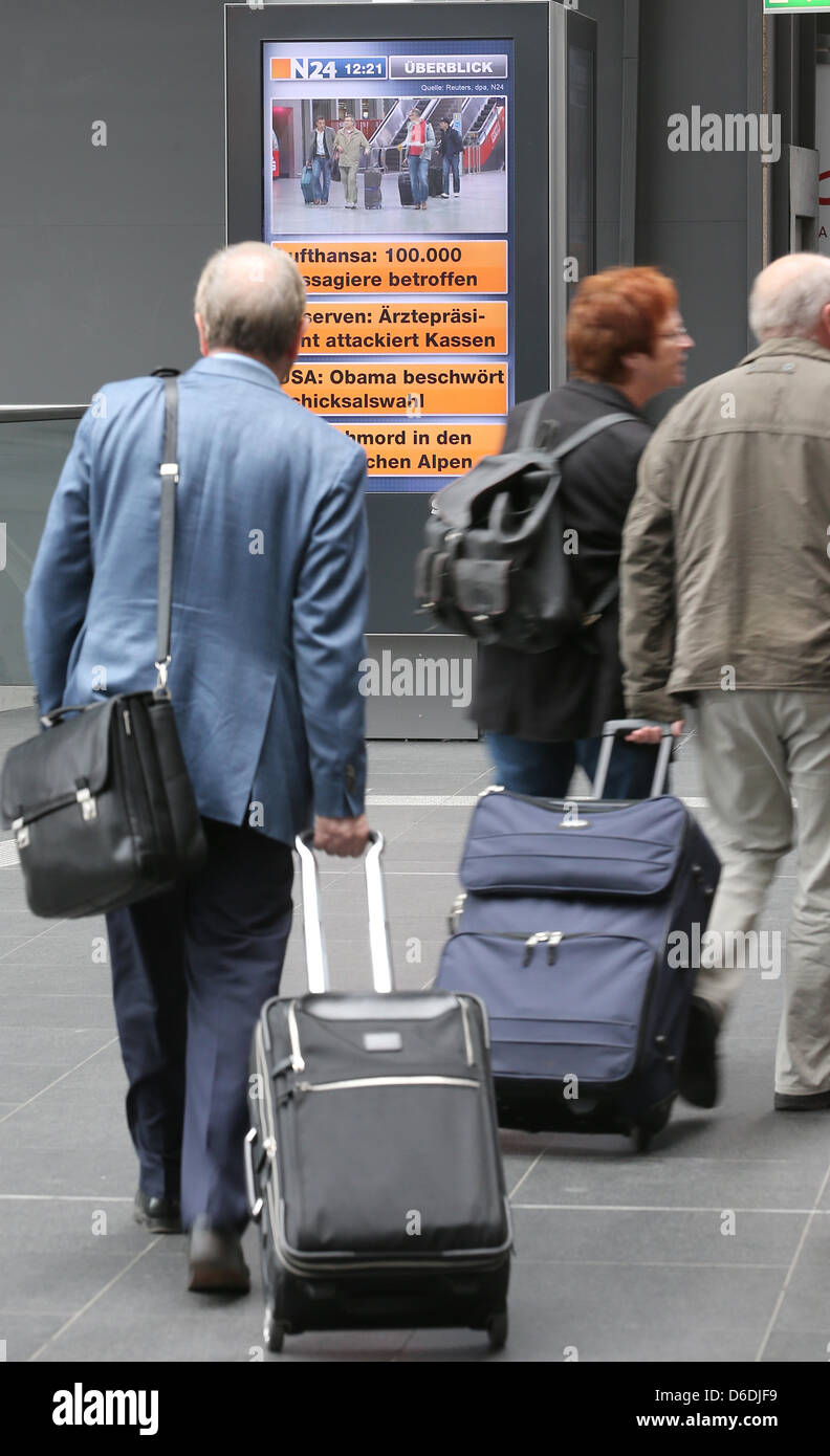 Les passagers à pied de leurs trains, tandis qu'un panneau d'affichage informe les gens sur les événements de la Lufthansa grève à la gare centrale de Berlin, Allemagne, 07 septembre 2012. Le syndicat Ufo a appelé à une grève nationale de 24 heures du personnel de bord de Lufthansa et un porte-parole de la Deutsche Bahn a annoncé que cela ne fait que le système ferroviaire. Photo : Wolfgang Kum Banque D'Images