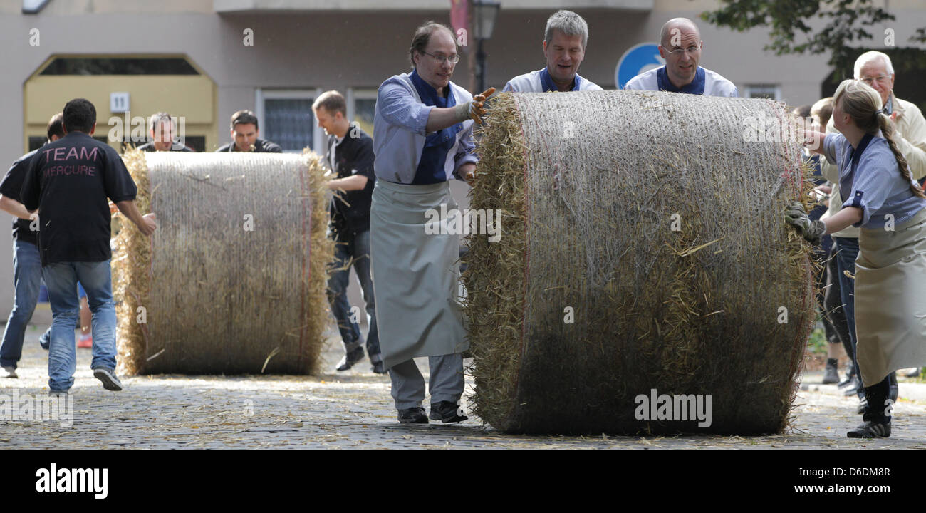 Deux équipes roll bottes de paille sur la place Richard Neukölln à Berlin, Allemagne, 08 septembre 2012. 20 équipes ont participé à la 179ème Rixdorf de roulement de la balle de paille. Photo : Spata Ole Banque D'Images