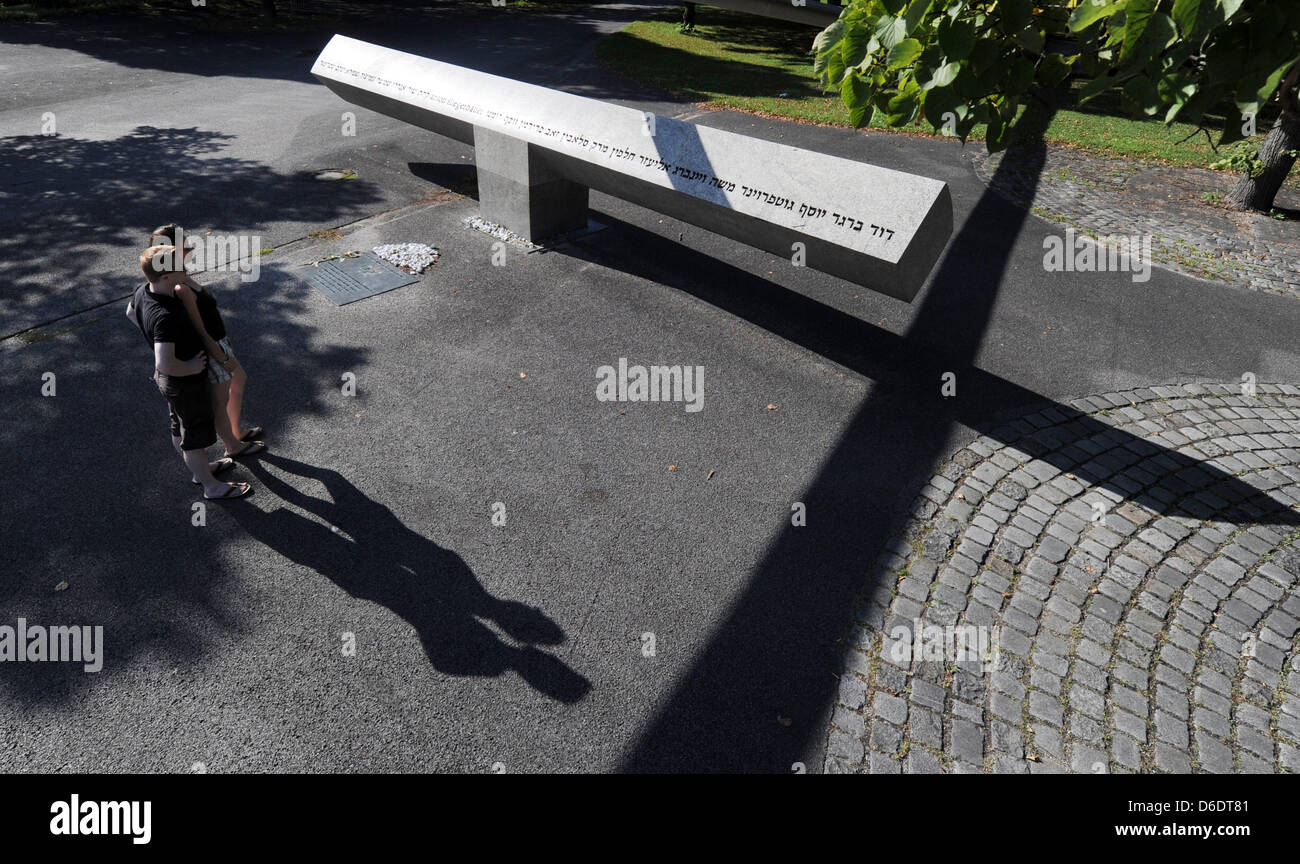 Les visiteurs regarder le mémorial pour les victimes de l'attaque terroriste au cours des Jeux Olympiques de 1972 à Munich sur un square à l'Olympiapark de Munich, Allemagne, 29 août 2012. 11 athlètes israéliens, un policier palestinien et cinq preneurs d'otages ont été tués dans l'attaque et la prise d'otages qui a eu lieu le 5 septembre 1972. Photo : Tobias Hase Banque D'Images