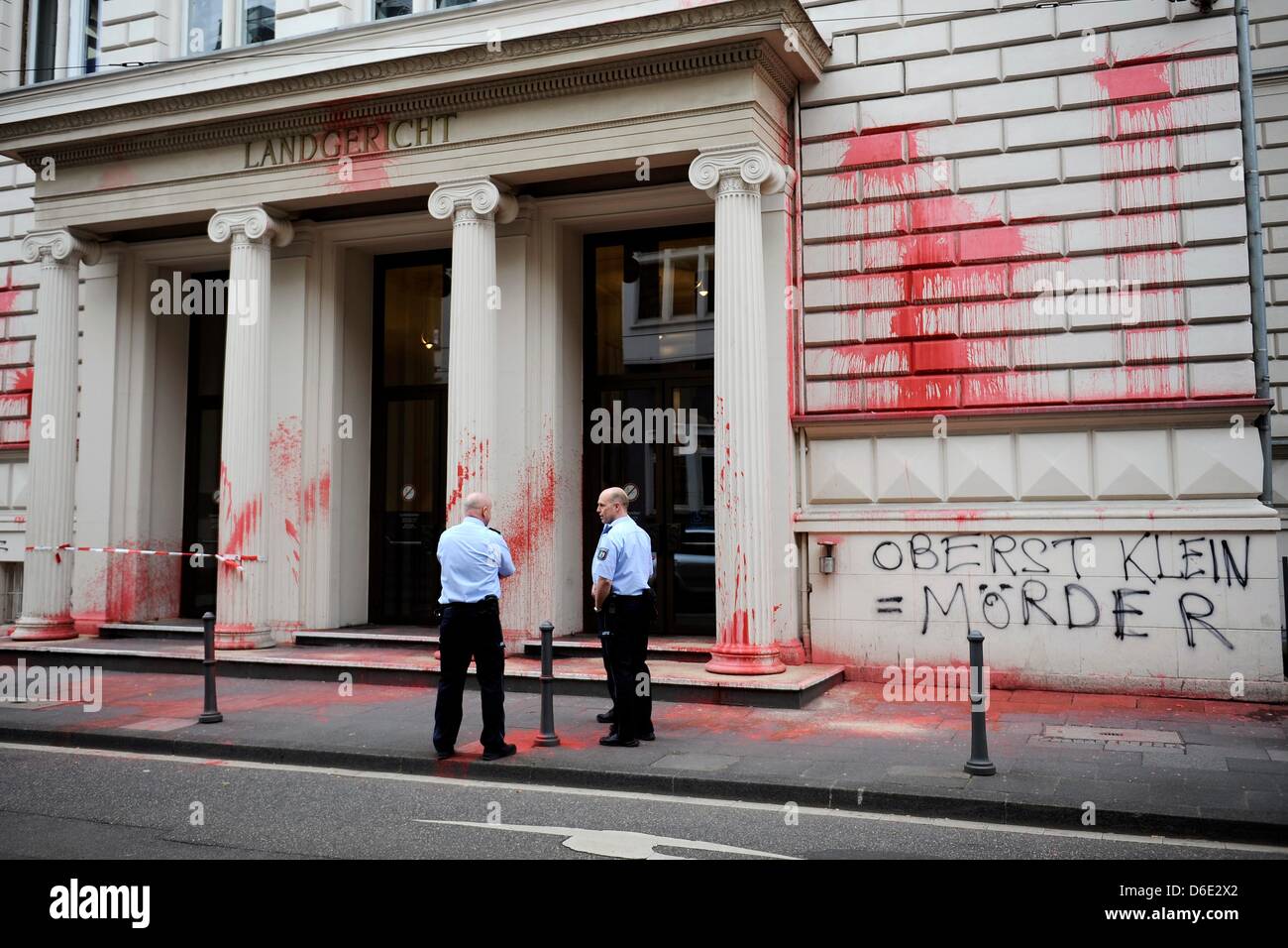 Bonn, Allemagne, 17 avril 2013. Les agents de police sont devant le tribunal régional, qui est inconnu enduite de couleur rouge sang et les mots "le Colonel Klein  = meurtrier', à Bonn, Allemagne, 17 avril 2013. La Cour entend les actions des forces armées allemandes à Kunduz, Afghanistan. Suivant l'ordre de Klein, les avions de l'OTAN ont bombardé deux navires-citernes suspectes, qui a tué près de 100 personnes. Photo : MARIUS BECKER DPA/Alamy Live News Banque D'Images