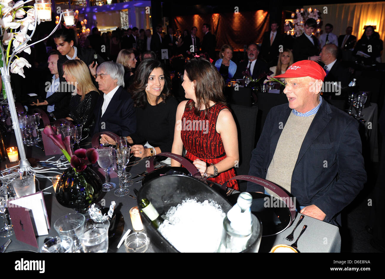 L'autorité principale de la Formule Un Bernie Ecclestone, magnat des affaires et (4-L), ancien pilote de course autrichien Niki Lauda (R) et son épouse Birgit (2-R) s'asseoir à la table au Kitz Race Party, un événement qui a lieu traditionnellement après la légendaire course de ski alpin descente du Hahnenkamm, à Kitzbuehel, Autriche, 21 janvier 2012. Le parti est un point de rencontre des gens célèbres. Pho Banque D'Images