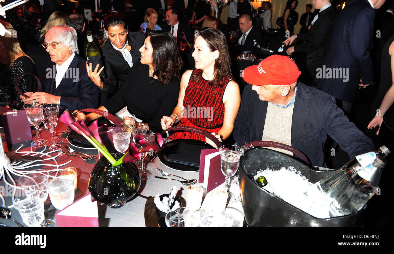 L'autorité principale de la Formule Un Bernie Ecclestone, magnat des affaires et (L), son partenaire Fabiana Flosi, ancien pilote autrichien Niki Lauda (R) et son épouse Birgit (2-R) s'asseoir à la table au Kitz Race Party, un événement qui a lieu traditionnellement après la légendaire course de ski alpin descente du Hahnenkamm, à Kitzbuehel, Autriche, 21 janvier 2012. La partie est une réunion po Banque D'Images