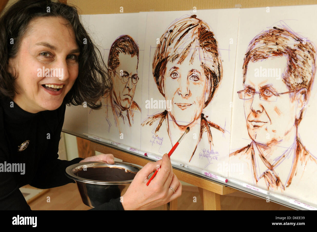 Artiste chocolat Grit Wendelberger son politiciany peintures comestibles (R-L) Le président allemand Christian Wulff, la chancelière allemande Angela Merkel et l'ancien ministre de la Défense Karl-Theodor zu Guttenberg dans son studio à Halle, en Allemagne, le 16 janvier 2012. L'portraist sont faites sur le pain azyme avec vitrage chocolat doux-amer et à l'encre à base de courants et sont entièrement comestibles. Ils peuvent être conservés comme Banque D'Images