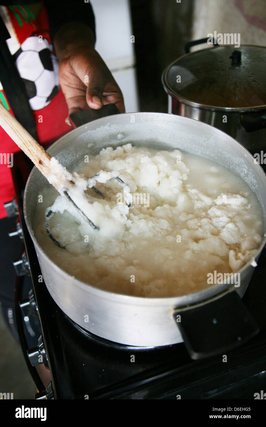Une femme africaine la préparation de bouillie sur une cuisinière électrique dans une baraque Banque D'Images