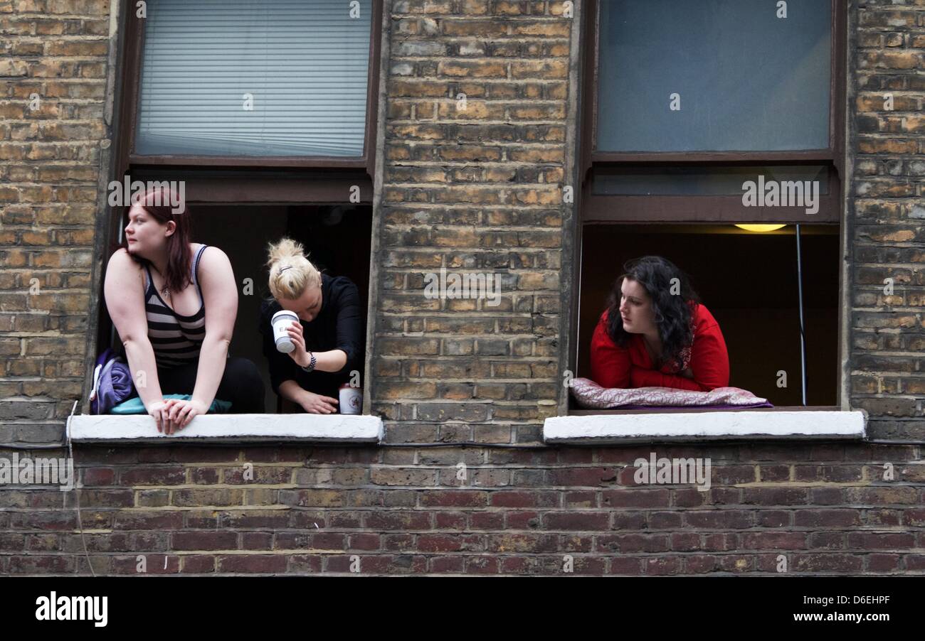 Londres, Royaume-Uni. 17 avril 2013. Lean résidents hors de leurs fenêtres à regarder des milliers de spectateurs bordent la route où le cercueil de la fin La Baronne Thatcher a voyagé de la chapelle de St Mary Undercroft au Palais de Westminster à la Cathédrale St Paul, à Londres. Thatcher, la première et seule femme Premier ministre du Royaume-Uni, est mort le 8 avril 2013 à l'Hôtel Ritz de Londres où elle avait été un séjour pour les derniers mois de sa vie. George Henton / Alamy Live News. Banque D'Images