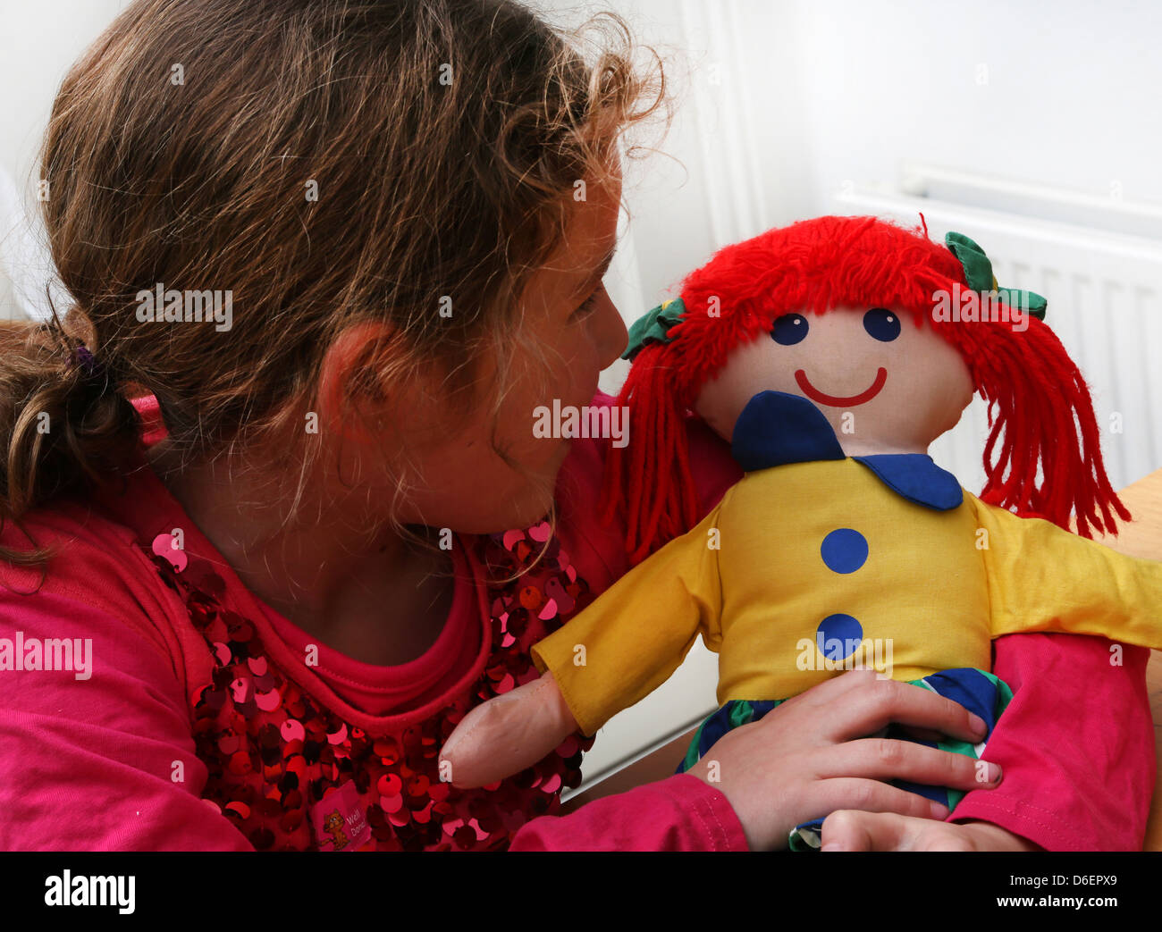 7 year old girl Holding Soft Toy Doll Angleterre Banque D'Images