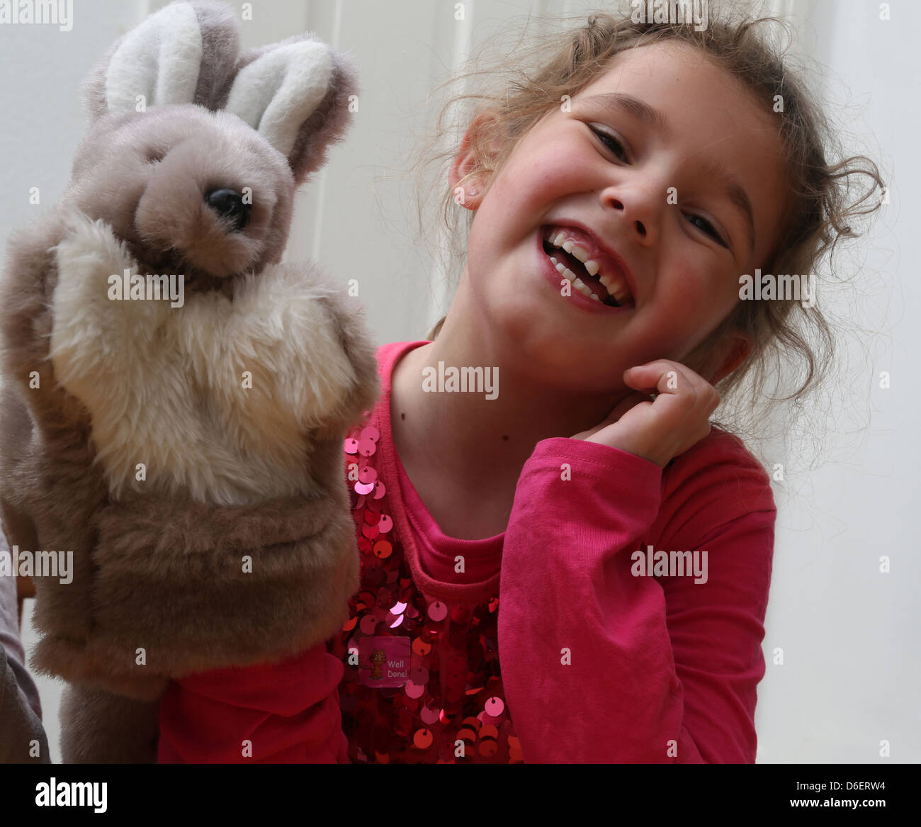 7 ans fille jouant avec Kangaroo Marionnette à main en Angleterre Banque D'Images