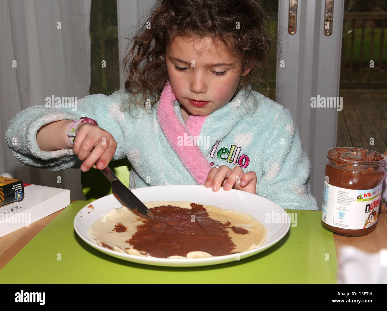 Propagation fille chocolat Nutella sur des crêpes Dimanche petit-déjeuner traiter l'Angleterre Banque D'Images