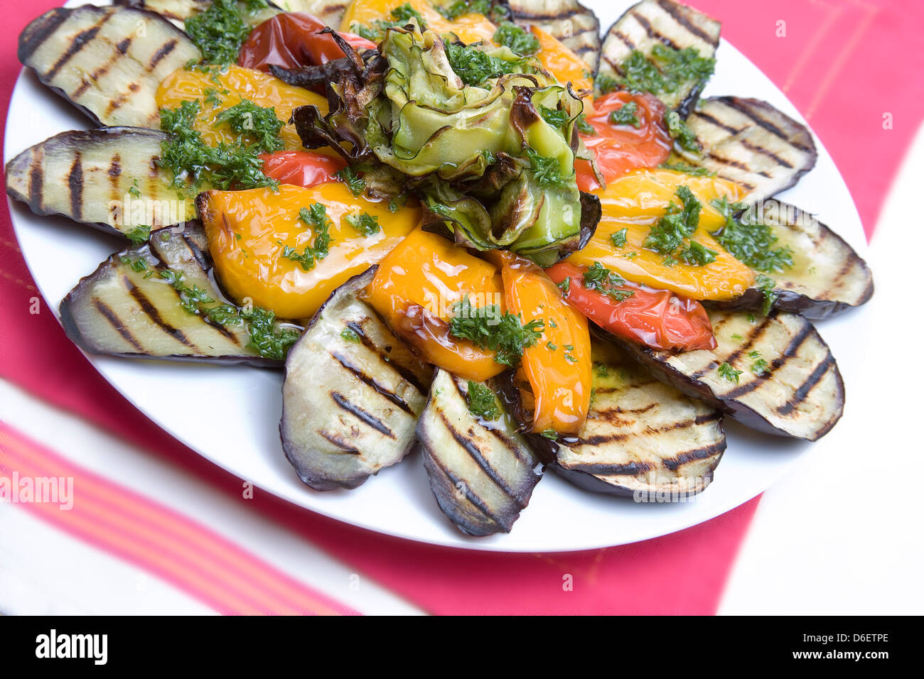 Aubergines grillées, poivrons et courgettes avec une vinaigrette aux fines herbes d'été. Banque D'Images