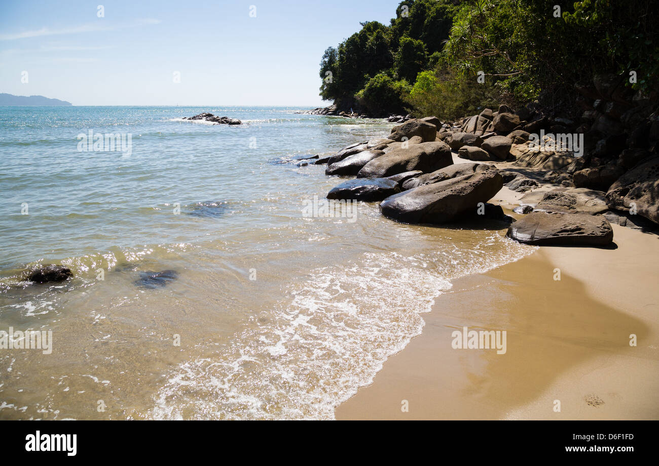 Rainforest vêtu pointe rocheuse bordée d'une plage de sable de Rasa Ria près de Kota Kinabalu en Bornéo Malaisien Banque D'Images