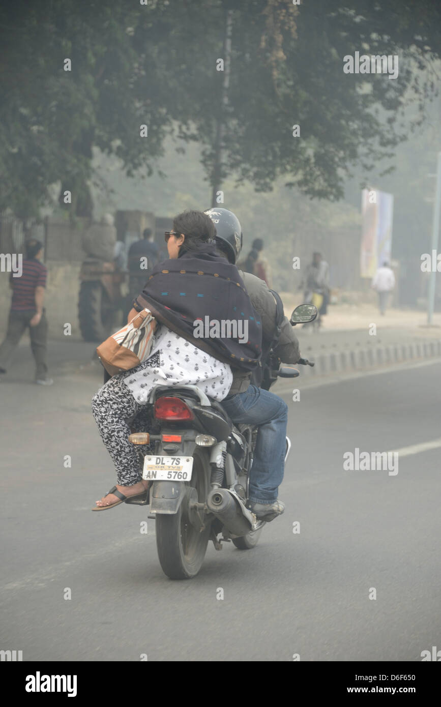 Une femme indienne équitation leurs à l'arrière d'une moto dans Delhi, Inde Banque D'Images