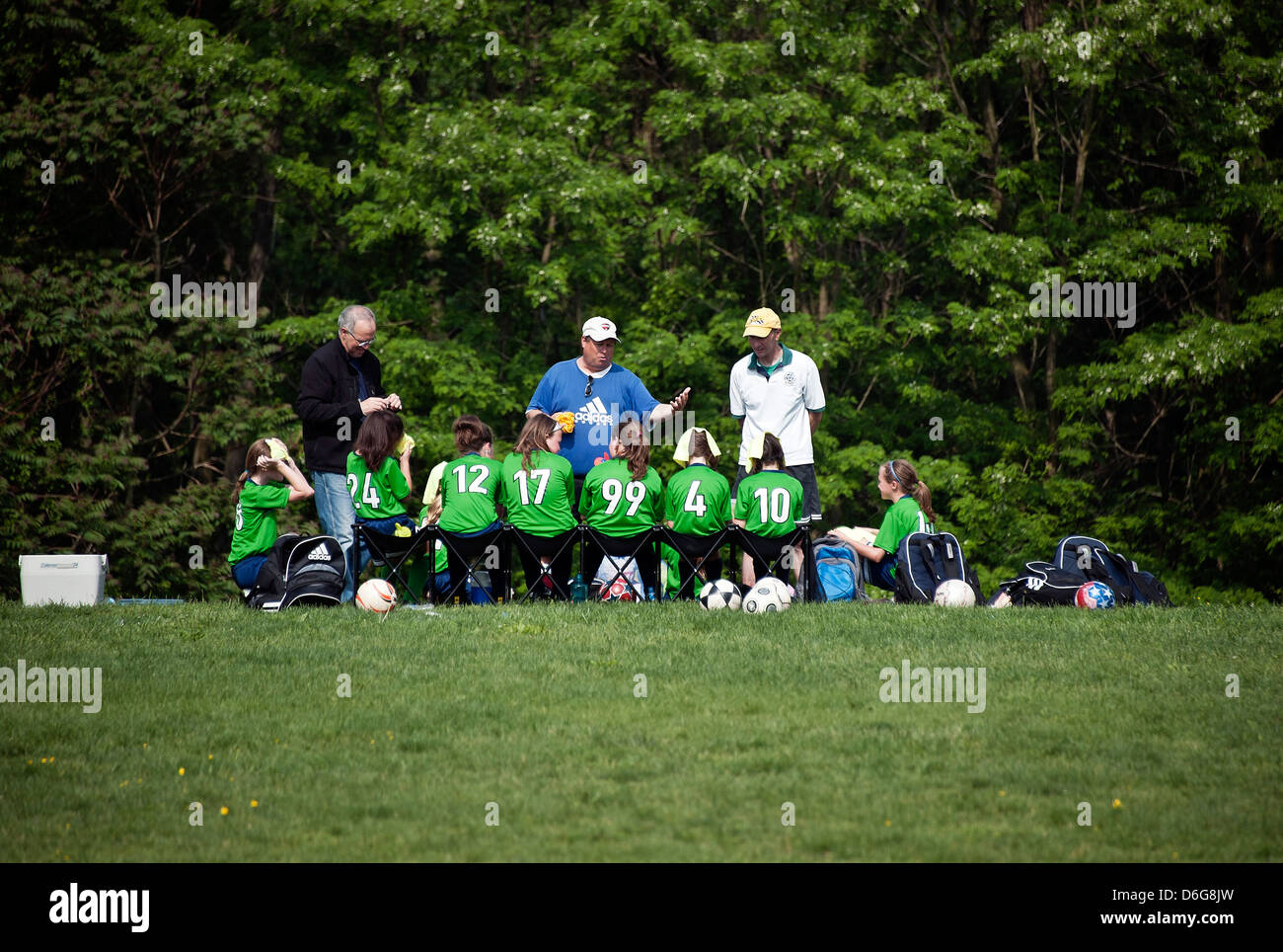 L'équipe de soccer pour les jeunes filles à la mi-temps avec l'entraîneur. Banque D'Images