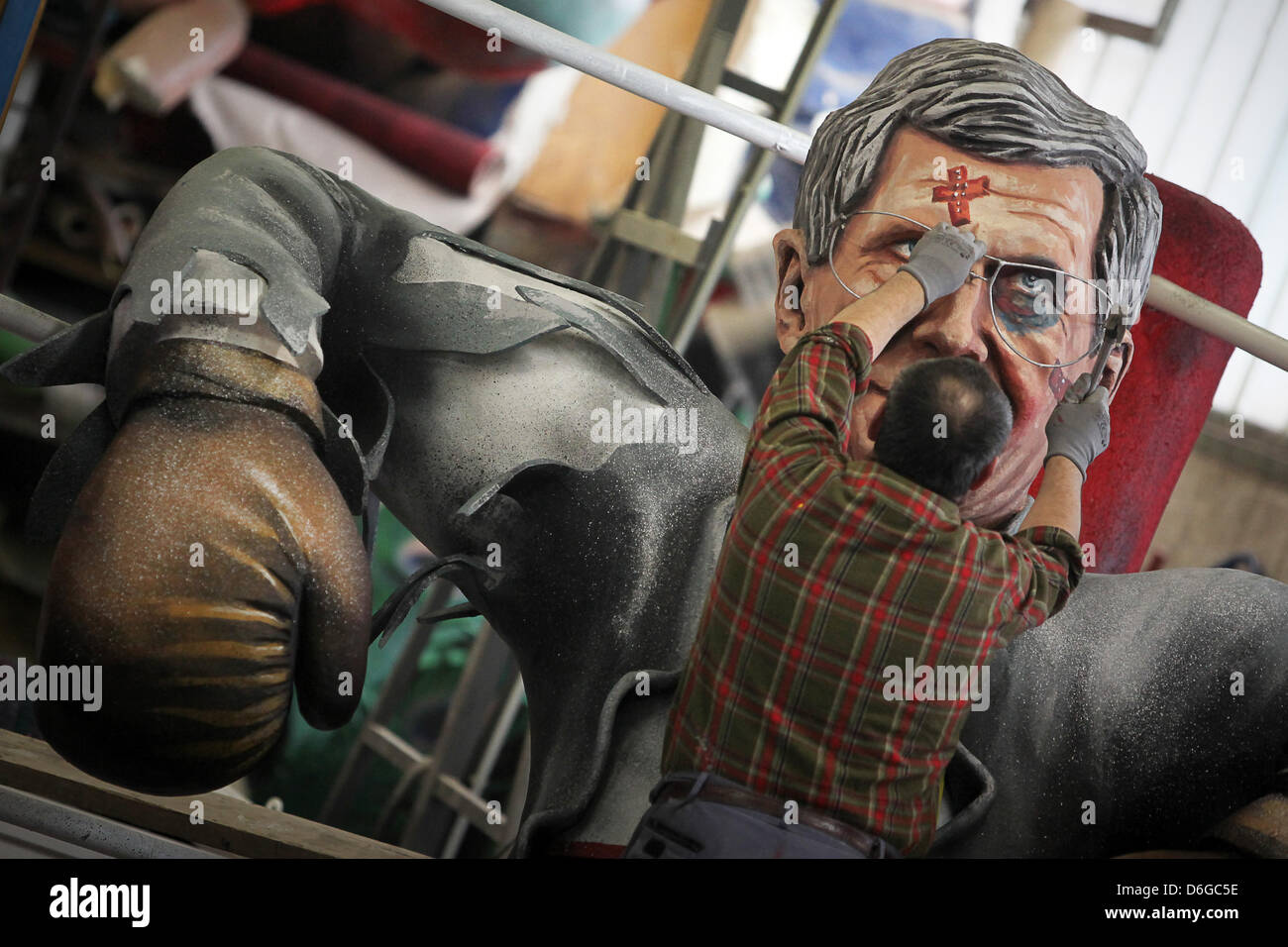 Un artiste ajuste la lunettes de la figure de battus, le Président allemand Wulff comme un boxeur à Mainz, Allemagne, 14 février 2012. Le Club de Mayence Carnibal a divulgué le secret de leur char pour le carnaval de cette année à Mayence. L'un des flotteurs, porte sur le scandale du président allemand WULFF. Photo : FREDRIK VON ERICHSEN Banque D'Images