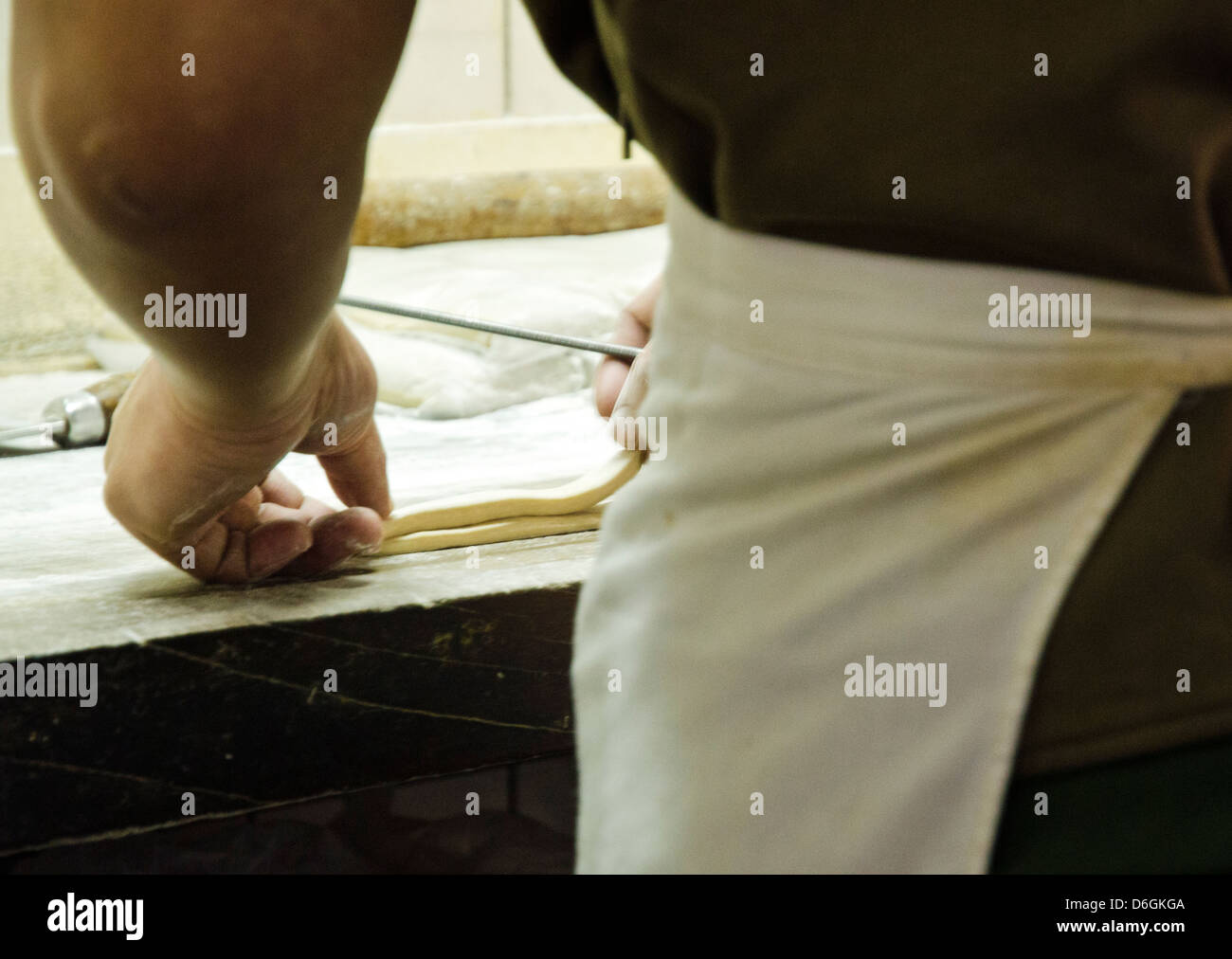 Faire cuire la préparation de longues bandes de pâte pour churos sur la table Banque D'Images