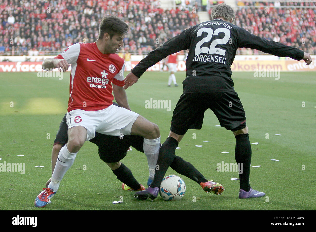 Mainz' Marco Caligiuri (C) convoite la la balle avec Kaiserslautern's Nicolai Jorgensen (R) et Pierre de Wit (couverte) au cours de la Bundesliga match de foot entre FSV Mainz 05 et FC Kaiserslautern à Coface Arena à Mainz, Allemagne, 25 février 2012. Mayence a remporté le match 4-0. Photo : Fredrik von Erichsen Banque D'Images