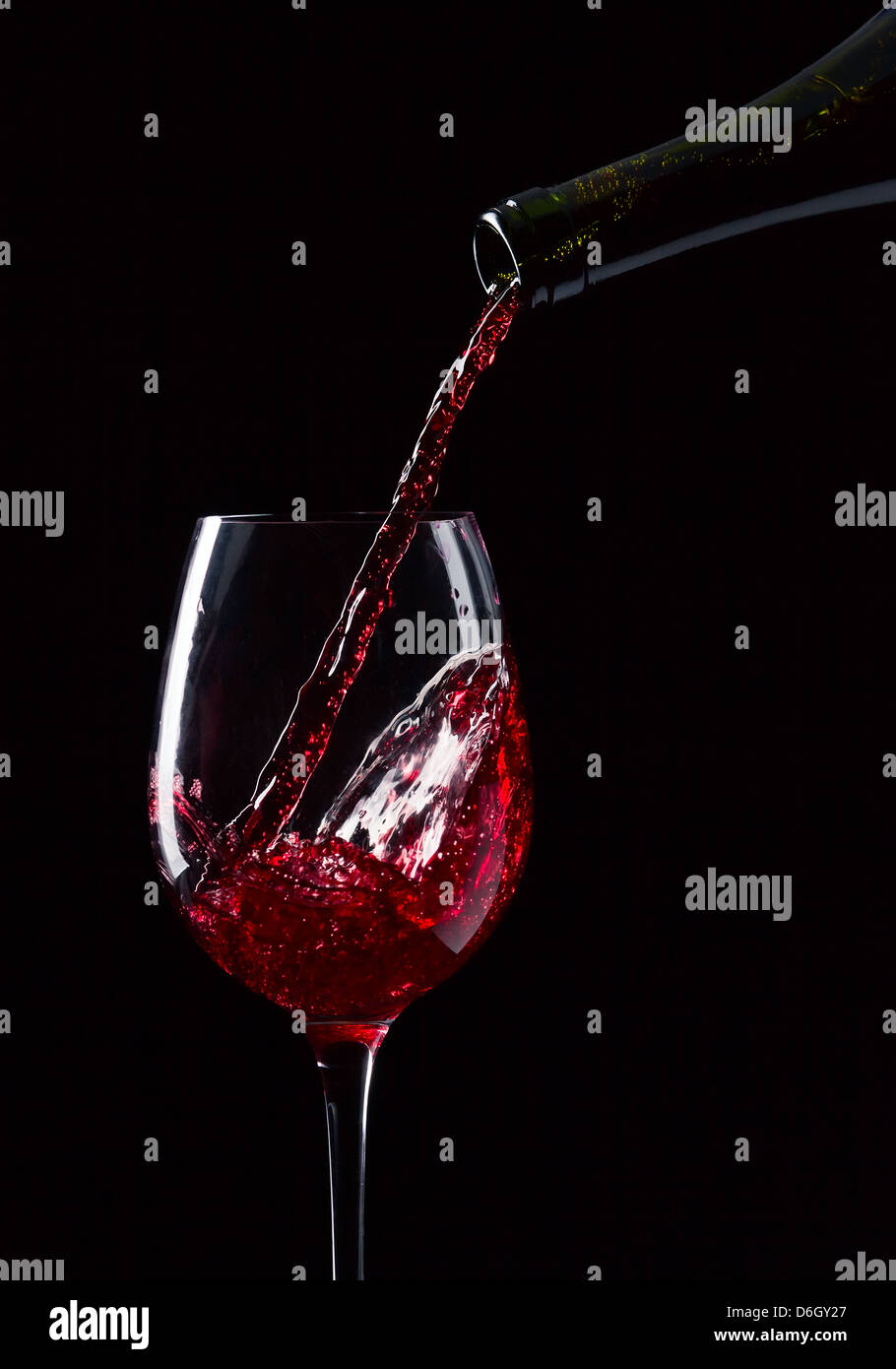 Bouteille et verre de vin rouge sur fond noir Banque D'Images