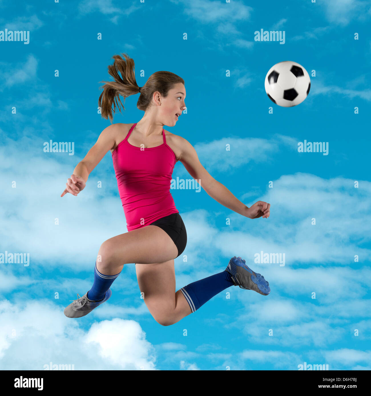 Soccer player kicking ball dans l'air Banque D'Images