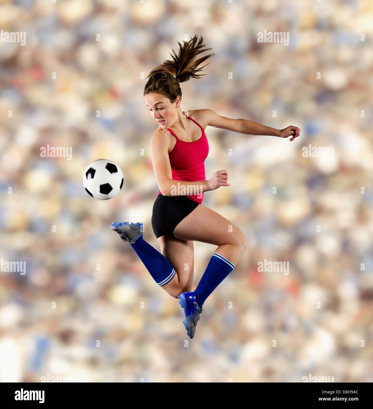 Soccer player kicking ball dans l'air Banque D'Images