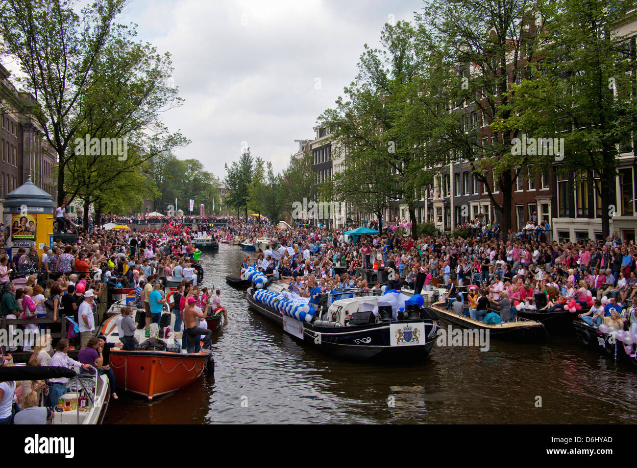 La parade de la Gay Pride dans un canal bordé de monde avec des personnes et des bateaux à Amsterdam, Hollande. Banque D'Images