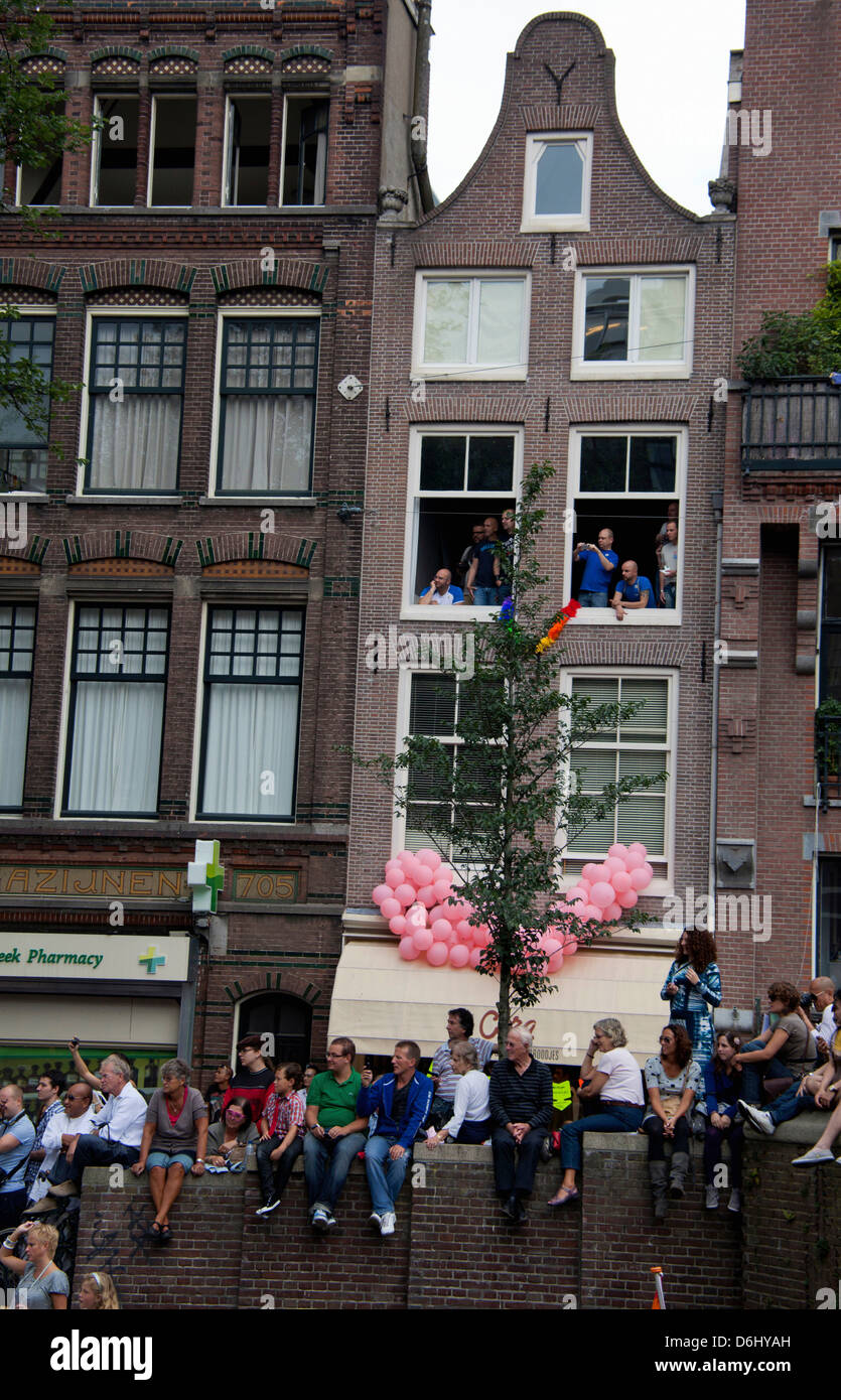 La parade de la Gay Pride dans un canal bordé de monde avec des personnes et des bateaux à Amsterdam, Hollande. Banque D'Images