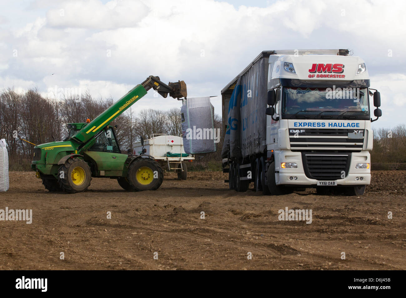 Télé John Deere handler le déchargement des sacs de pommes de terre de semence de l'écossais d'un camion Banque D'Images