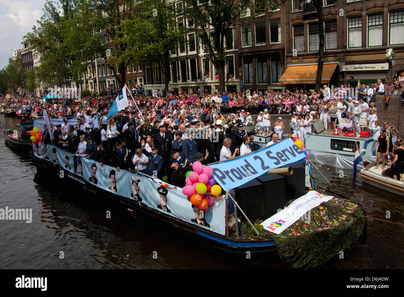 La parade de la Gay Pride dans un canal bordé de monde avec des personnes et des bateaux à Amsterdam, Hollande. Gay-forces armées. Banque D'Images