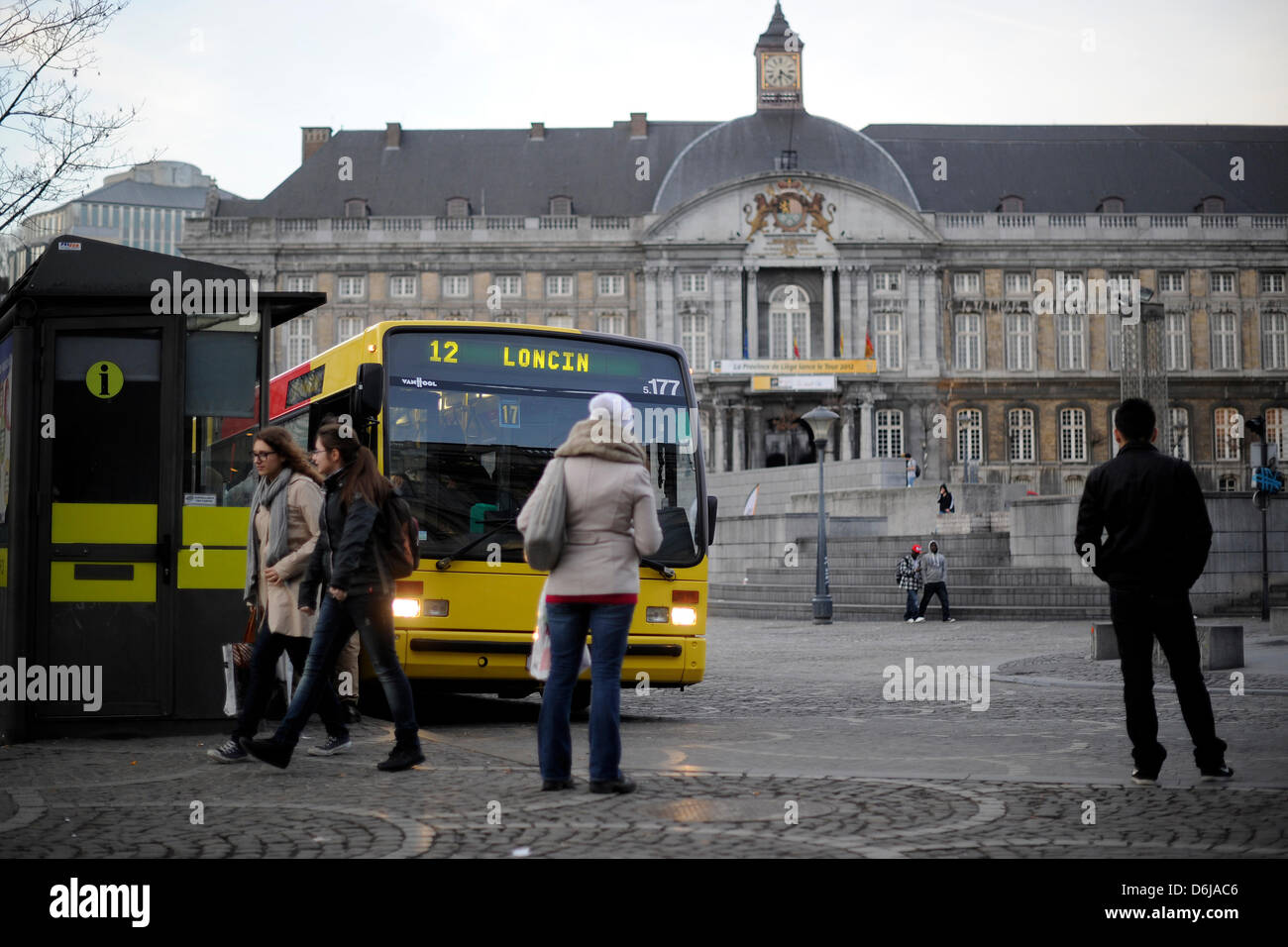 Les piétons attendez un bus sur la Place Saint-Lambert à Liège, Belgique, 08 mars 2012. Le Palais des Princes-Évêques, l'actuel palais de justice, est représentée dans l'arrière-plan. Photo : Marius Becker Banque D'Images