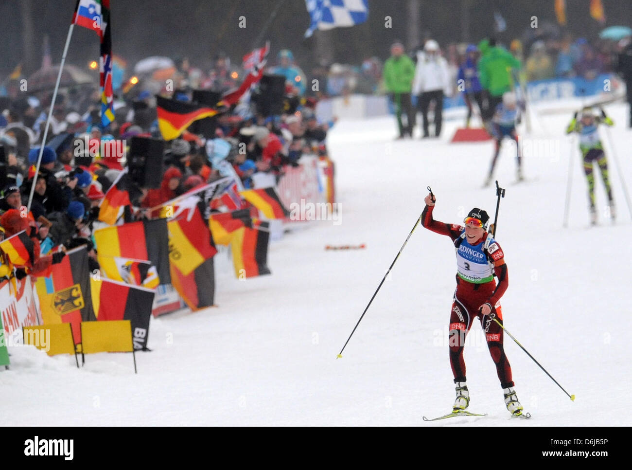 Le biathlète norvégienne Tora Berger cheers comme elle arrive à la ligne d'arrivée dans le women's 12,5km départ groupé compétition durant les Championnats du monde de biathlon à Ruhpolding, Allemagne, 11 mars 2012. Berger a remporté la troisième place. Photo : Andreas Gebert Banque D'Images