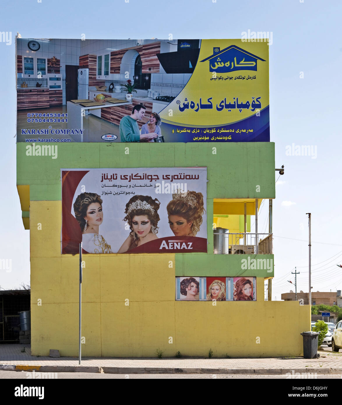 Les panneaux publicitaires accroché sur le côté d'un bâtiment dans la ville d'Erbil, Irak. Banque D'Images