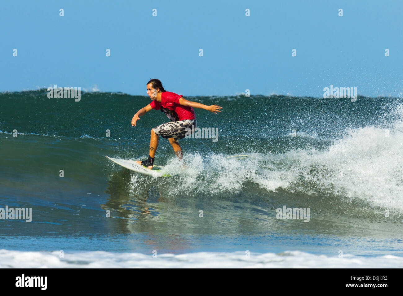 Surfer sur la vague d'équitation shortboard à Playa Guiones populaire plage de surf, Nosara, Péninsule de Nicoya, Province de Guanacaste, Costa Rica Banque D'Images