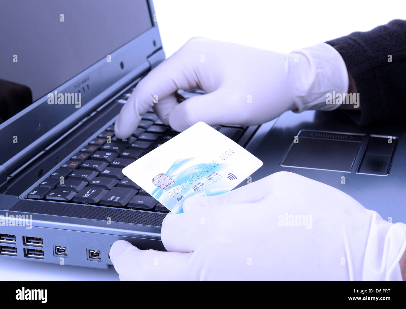Voleur avec gant de protection vol en ligne avec carte de crédit volée avec un filtre bleu de la négativité Banque D'Images