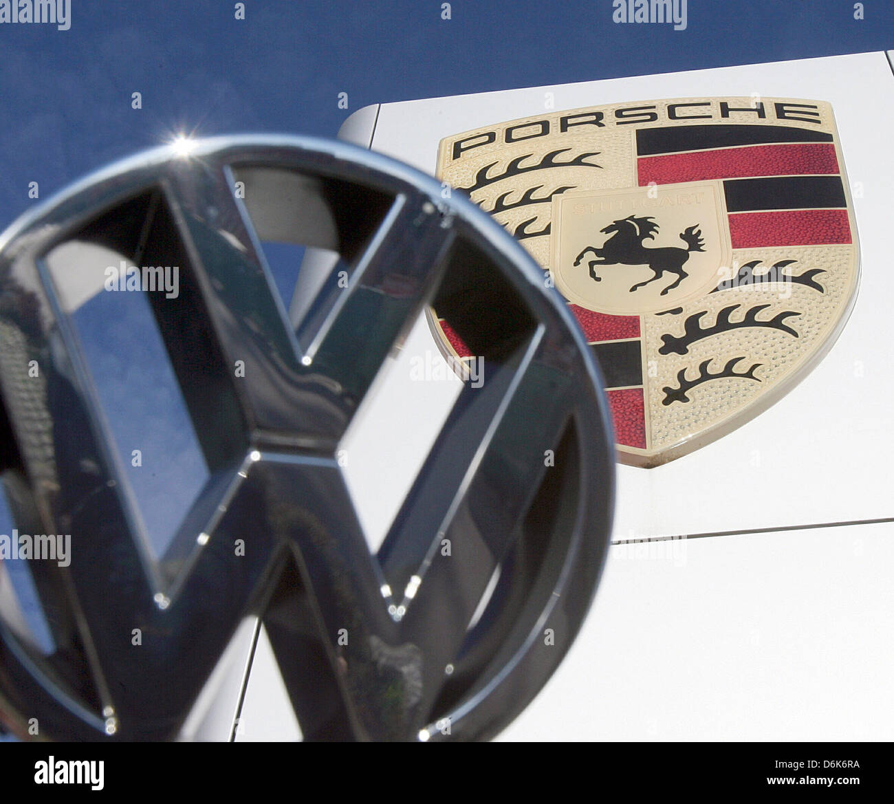 Fichier - An illustrated archive photo datée du 20 novembre 2006 montre le logo de fabricant de voiture Volkswagen (VW) en face de la Porsche logo au centre Porsche à Stuttgart-Zuffenhausen, Allemagne. VW a annoncé le 04 juillet 2012 qu'ils allaient prendre le relais de l'entreprise Porsche voiture de sport. La prise doit être achevé le 01 août 2012. Photo : Bernd Weissbrod Banque D'Images