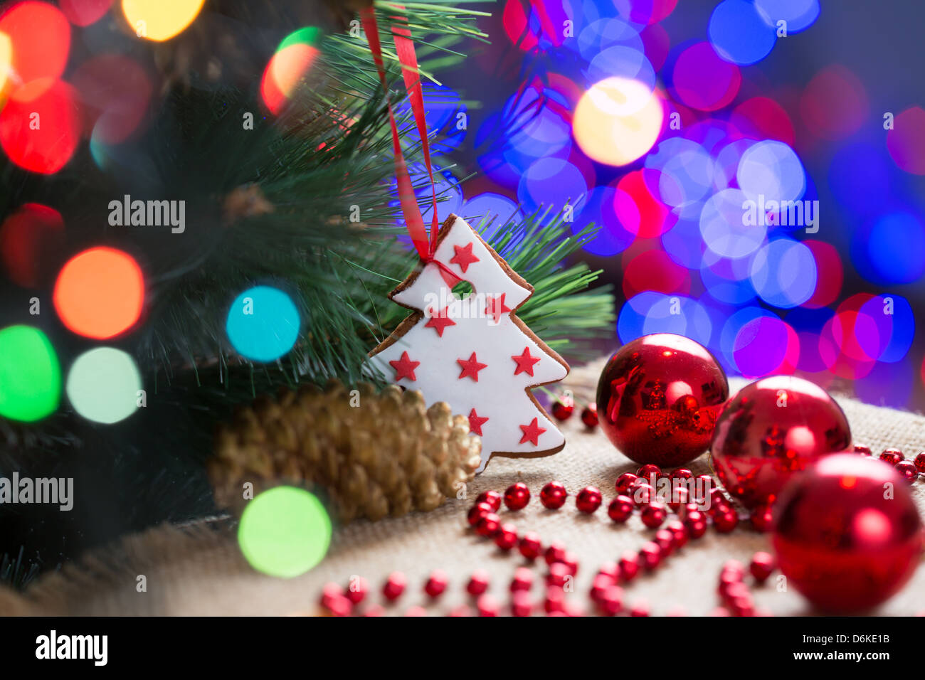 Arbre de Noël avec hochet et gâteau sur fond de fête lumineuse Banque D'Images