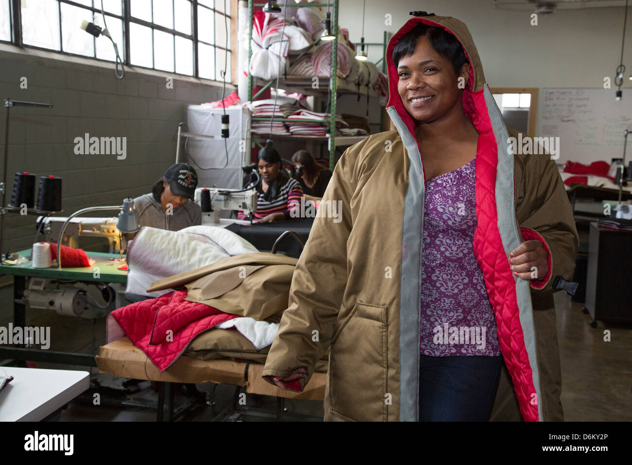 Un travailleur sur le plan de l'habilitation des organismes sans but lucratif un manteau dont les modèles anciens sans-abri, les femmes font pour les sans-abri. Banque D'Images