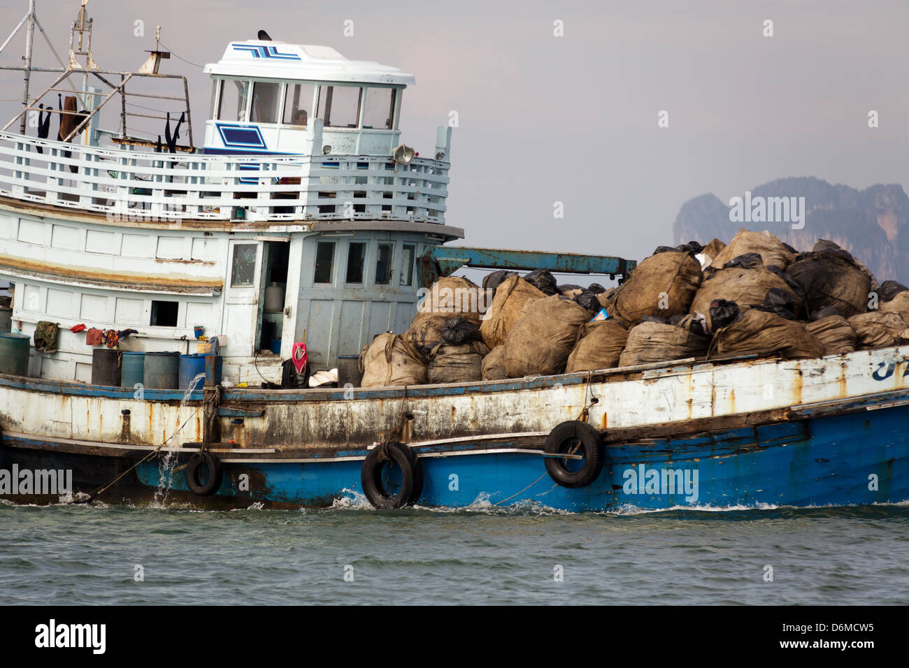 La pêche traditionnelle thaïlandaise et marchandises navire transportant des sacs de nourriture, Thaïlande Banque D'Images