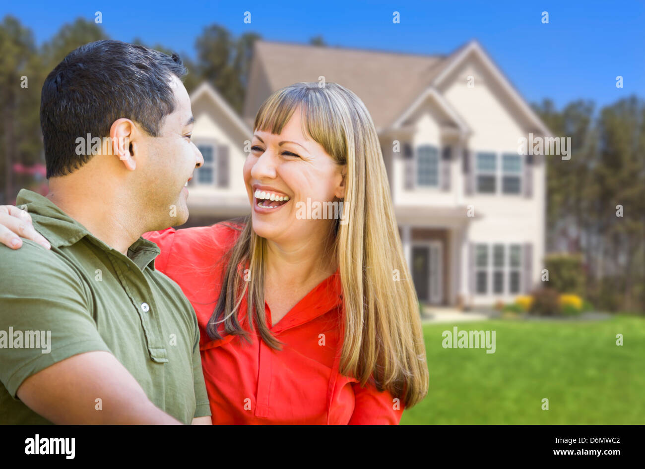 Happy Mixed Race Couple en face de belle maison. Banque D'Images