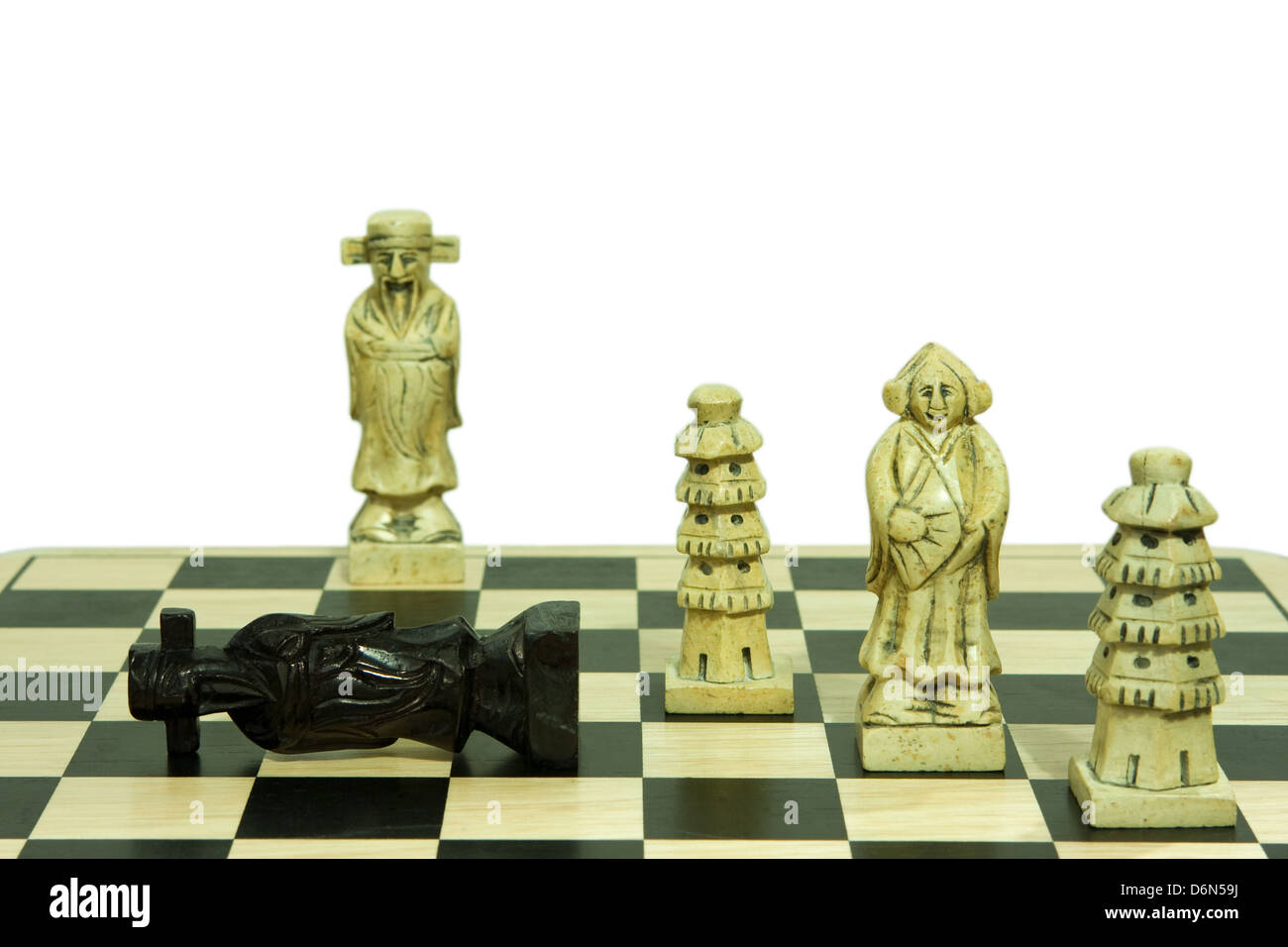 Un jeu d'échecs en pierre montrant un mat se déplacer sur le roi noir isolé sur fond blanc Banque D'Images