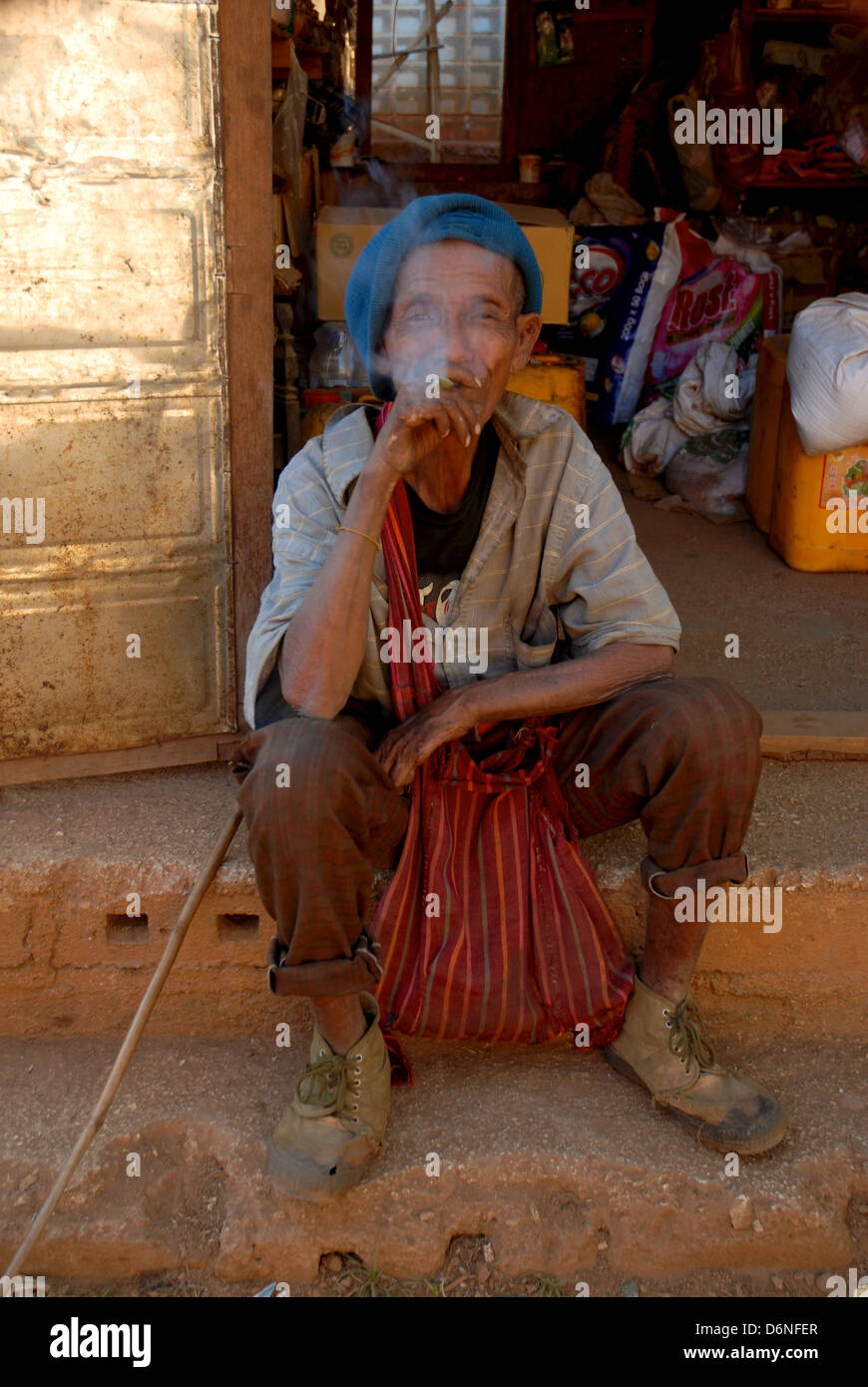 Homme assis birman sur l'étape de shop fumer un cigare Banque D'Images