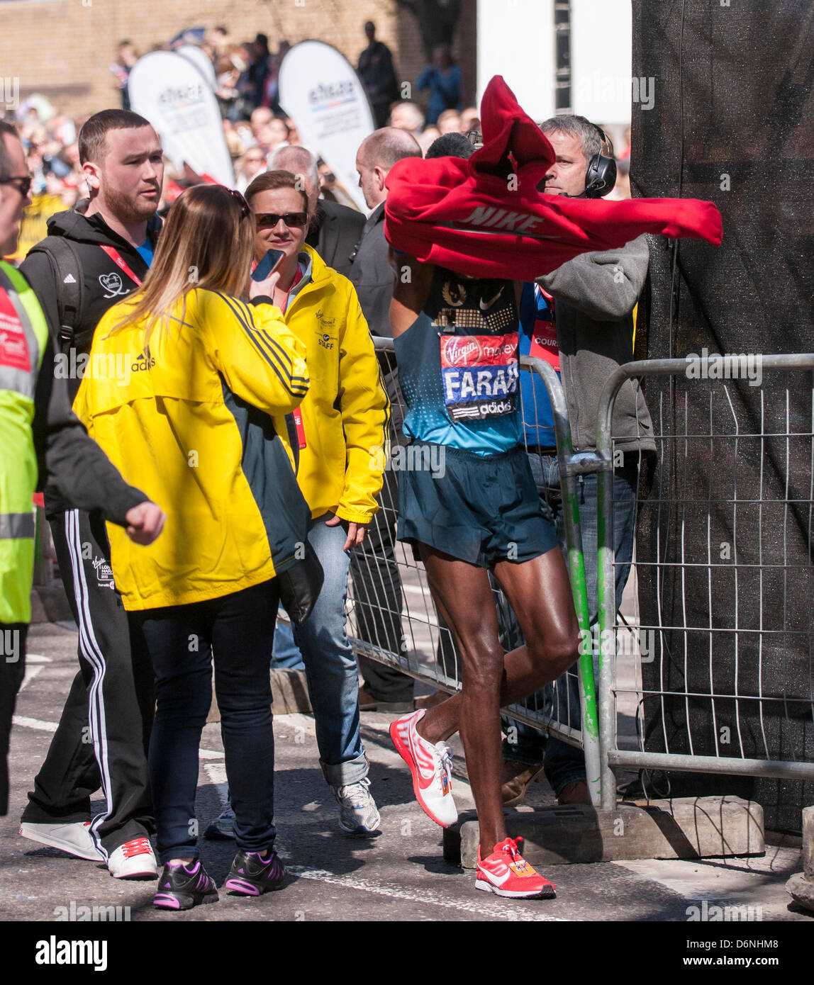 Londres, East Smithfield, 21 avril 2013. Mo Farah, le somalien né et de l'équipe Go double médaillé aux Jeux Olympiques de dans le 5 000m et 10 000m en 2012 à Londres, met son sweat du promoteur après avoir terminé sa course, juste avant de m 13. Avant la course Farah avait dit qu'il voulait rester avec l'élite hommes coureurs de marathon jusqu'à mi-chemin et il a fait exactement cela. Banque D'Images