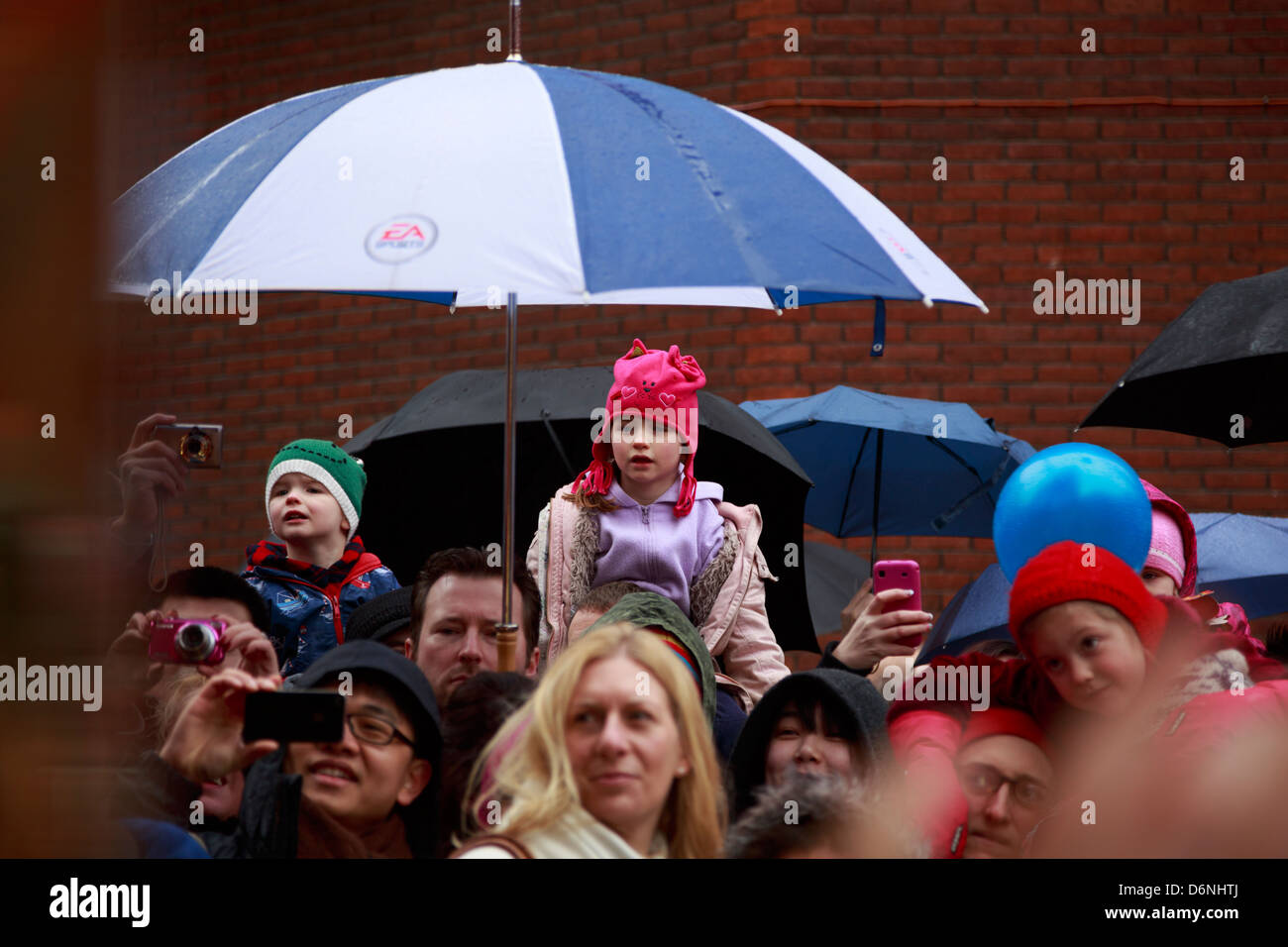 Les gens qui regardent un spectacle de danse du lion dans Chinatown de Londres pendant le Nouvel An chinois 2013 Banque D'Images